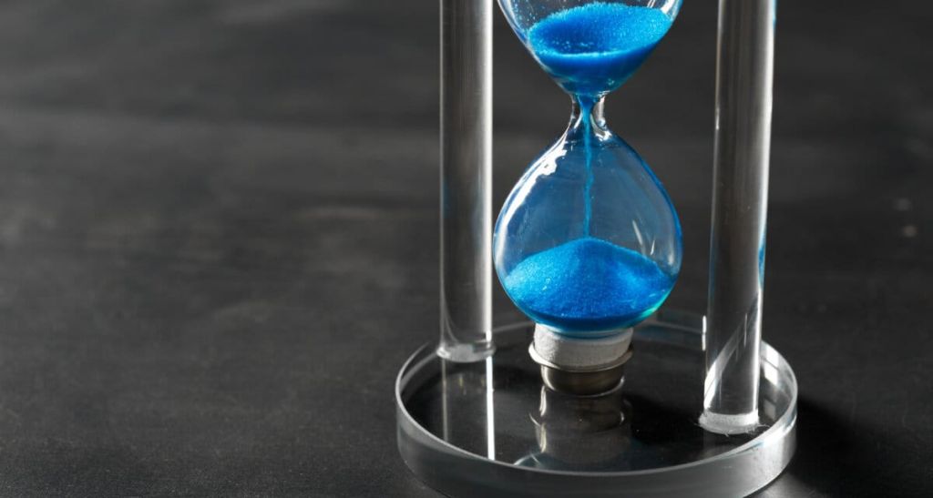Time is passing Blue hourglass close up